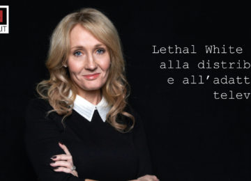 JK Rowling fotografata a mezza figura, a braccia conserte, sorridente, su sfondo nero.